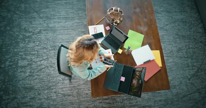 Overhead View of Woman Working with Multiple Devices and Documents