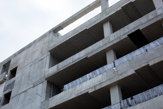 close-up of a part of a multi-storey residential building made of concrete and metal, construction of a new multi-storey building. Building under construction. Abstract architecture fragment