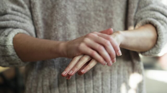 Video of close up of woman taking care while putting cream on her hands at home  