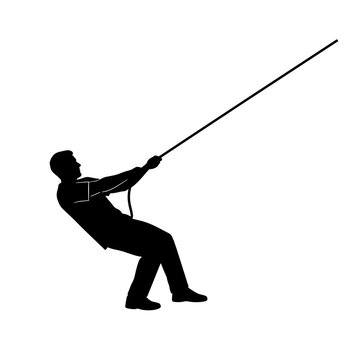 Silhouette of a person leaning back and pulling hard on a rope angled upwards.