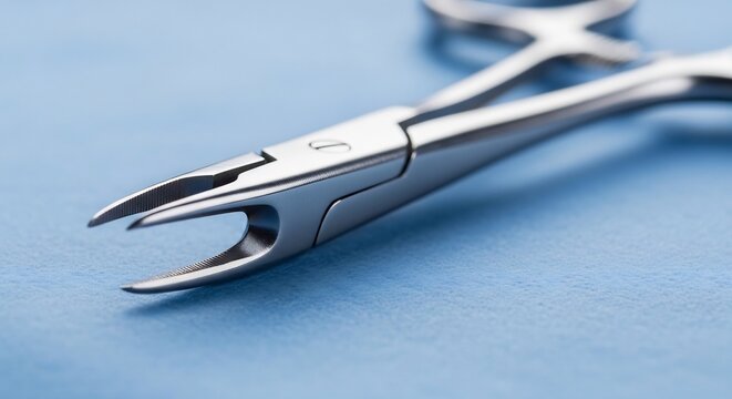 Close up of surgical hemostat forceps on a blue background.