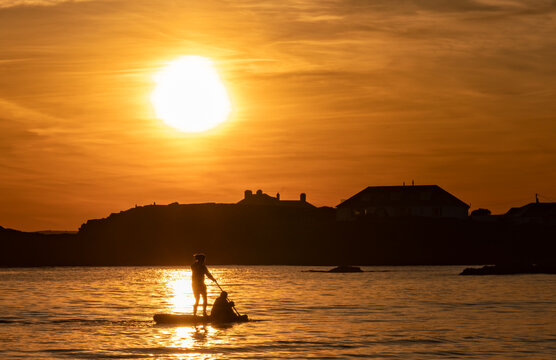 Paddle boarders at sunset at Trearddur bay Anglesey