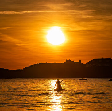 Paddle boarders at sunset at Trearddur bay Anglesey