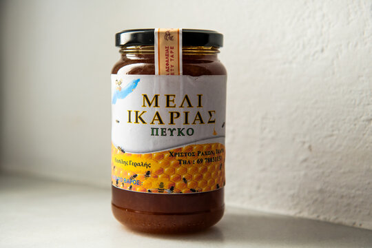 Christos Raches, Greece - June 11, 2023: Raw wild pine pefko honey of wildflowers at Ikaria, Greek longevity blue zone in glass jar bottle