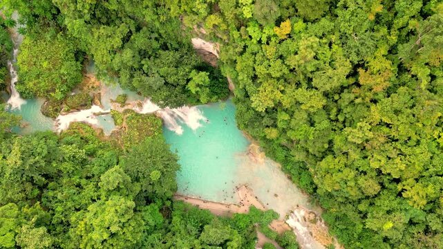 Tropical Waterfall Oasis. Turquoise Waters Sourced From Cascading Falls Among Thick Lush Foliage