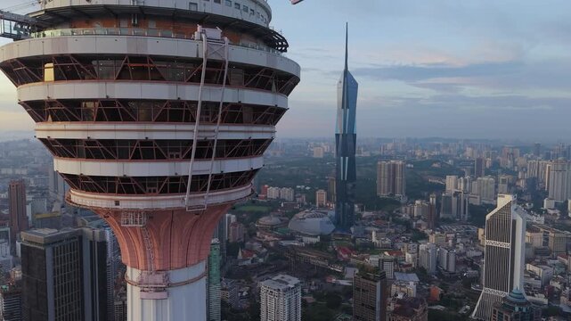 Kuala Lumpur, Malaysia - 04 April 2026: Aerial view of KL Tower in the foreground with Merdeka 118 skyscraper and the city skyline under a soft evening sky.