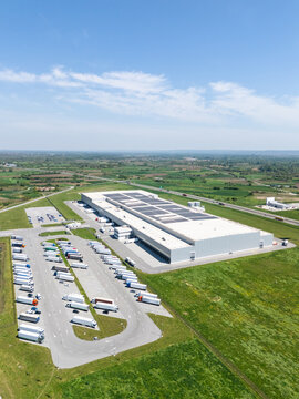 Aerial view of a modern logistics center with solar panels on the roof