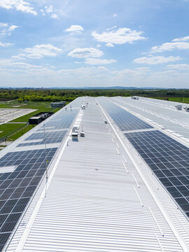 Aerial view of a modern logistics center with solar panels on the roof