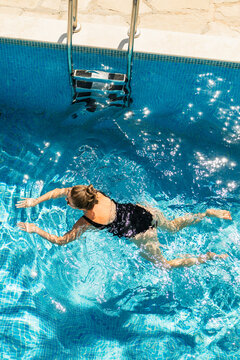 Adult 40 years old woman is resting in a swimming pool