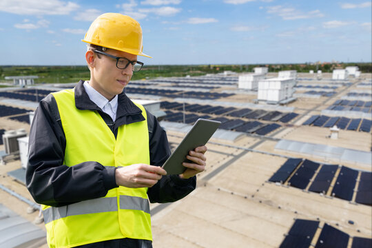 Technician managing large-scale solar power system on a commercial warehouse