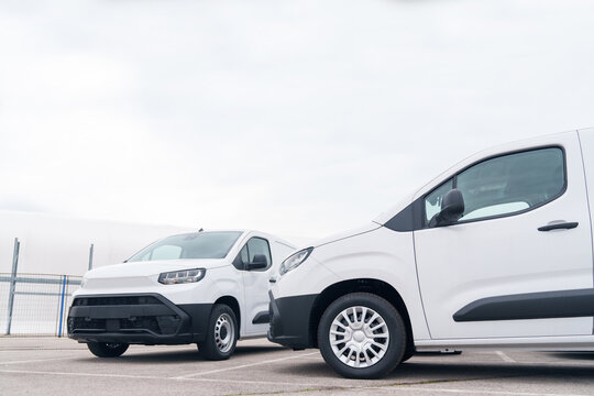 White delivery vans are parked in rows. Commercial fleet of vehicles
