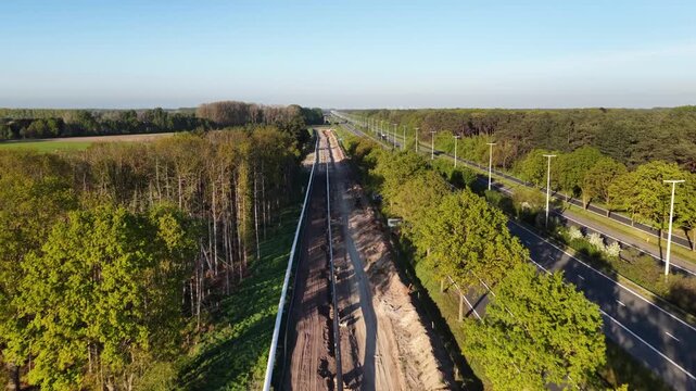 New gas pipeline construction next to highway in agricultural fields at dusk