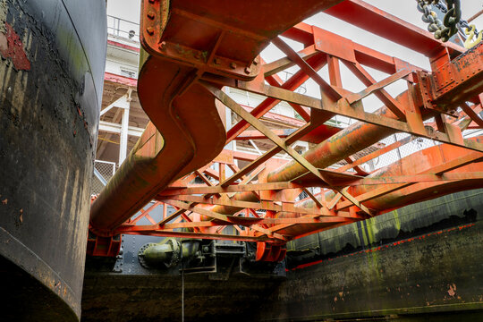 Wide suction head with drag shoe and dual intake pipes on vintage  river dredge in dry dock