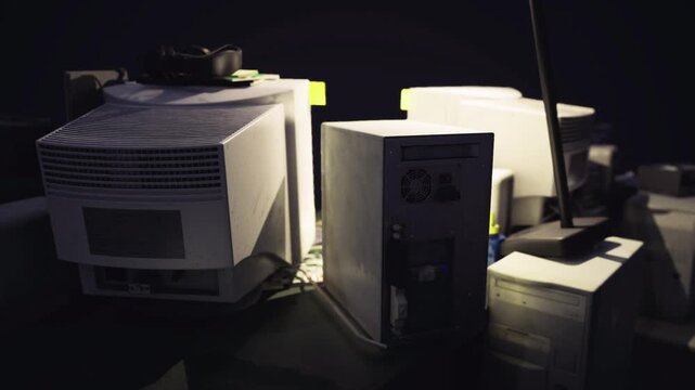 Stacks of towers and components bathed in warm spotlight, prototype cases, adhesive tape, tools, startup garage energy, handson innovation.