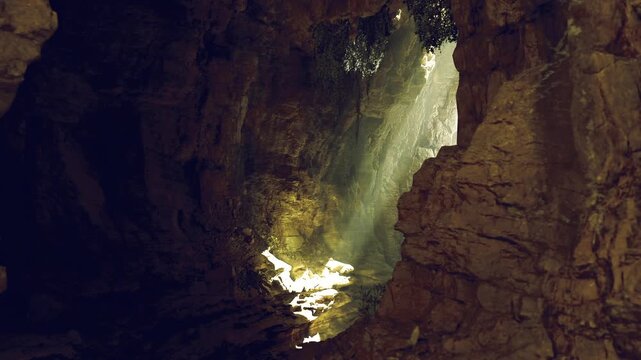 Sunlit grotto mammoth cave system revealing mossy floor and narrow daylight shaft, rugged limestone walls, warm golden beam and dust motes creating tranquil