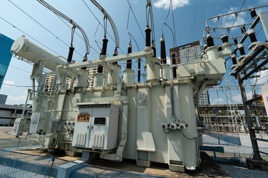Large Electrical Transformer Station with Power Lines Under Blue Sky in Urban Setting