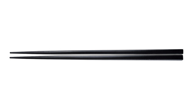 Pair of sleek black chopsticks subtly textured, isolated on transparent background