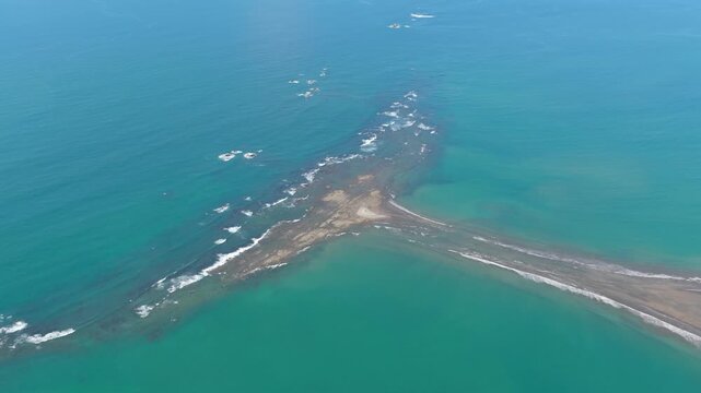 High altitude view of the iconic whale's tail shaped sandbar in Uvita. This famous tombolo is a natural wonder of the Marino Ballena National Park