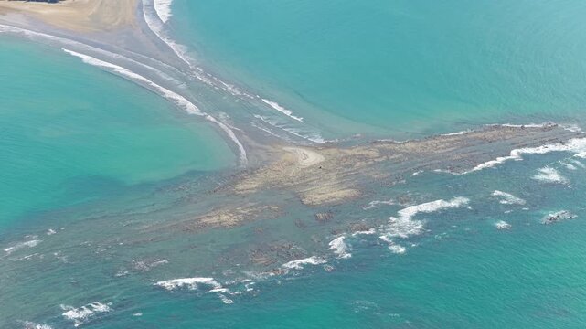 High altitude view of the iconic whale tail shaped tombolo at Marino Ballena National Park in Uvita, Costa Rica. A natural sandbar formation