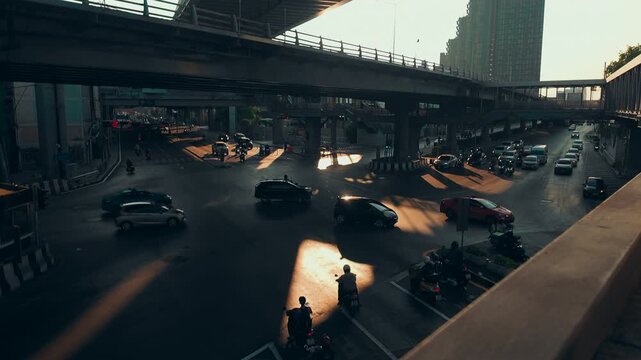 Urban traffic under elevated bridge with cars and sunlight shadows timelapse, City road with overpass infrastructure and busy transport during rush hour hyperlapse, Bangkok Thailand