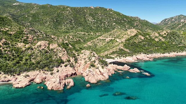 Aerial view of Su Sirboni Beach, Marina di Gairo, Sardinia, Italy. Turquoise sea, rugged red cliffs and hidden coves along the wild Ogliastra coastline
