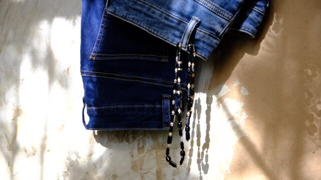 In the quiet intimacy of a home wardrobe, jeans and jewelry rest side by side, casual grace and understated glamour.