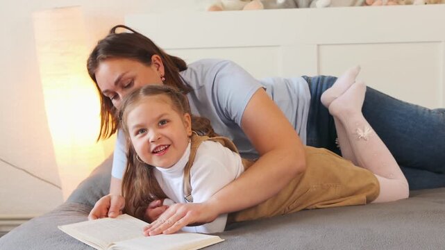 A teacher or nanny reads a story to a child in a cozy room. Early language skills and interactive learning. Close up