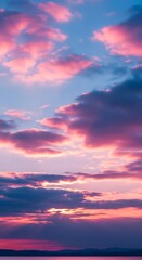 Obraz premium Dramatic sunset paints sky with vibrant pink, purple, and blue clouds over calm water