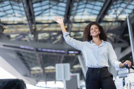 Tourist waving hand try to catch a taxi at the airport