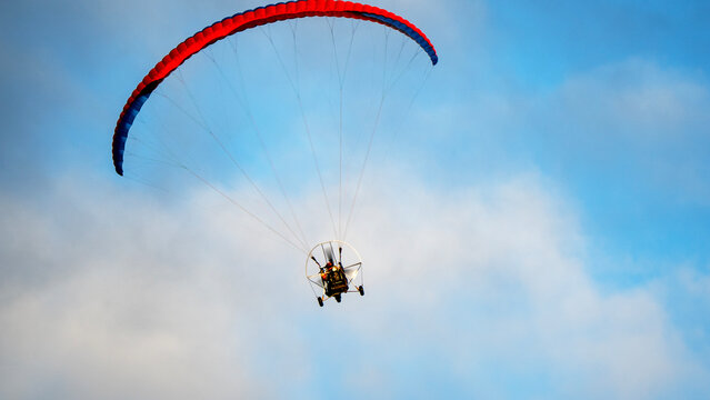 Paraglider soars above fluffy clouds