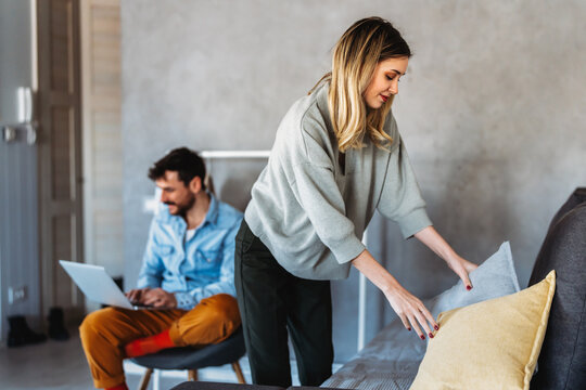 A couple disconnection as technology pulls the man away while the woman handles home tasks