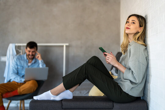 Couple balancing remote work and digital communication at home, reflecting freelancing, productivity