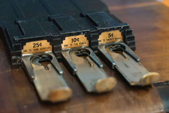 Guide Shows Different Coin Holders for Quarters, Dimes, and Nickels on a Wooden Surface in a Close-Up View