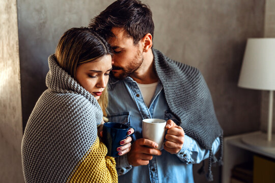 Wrapped in blankets, a couple faces emotional burnout and mental fatigue while supporting each other