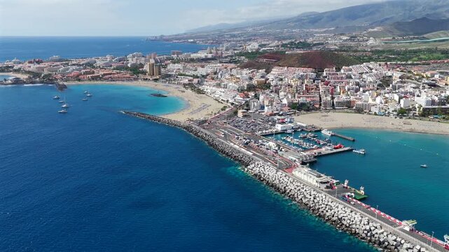 Aerial View of Playa de las Americas and Los Cristianos; Sailboats Anchored in Turquoise Bay with people swimming at the beach