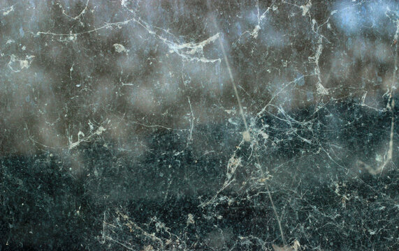 Eerie background of spider webs and dust on dirty glass. Grunge overlay.