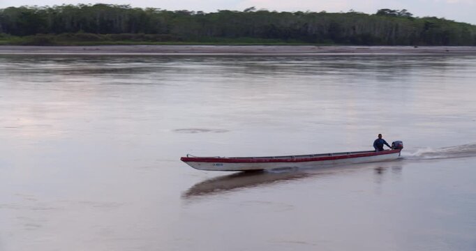 Canoe traveling on the Rio Napo in the Ecuadorian Amazon at dusk.Rio Napo is a major tributary of the Amazon. At Pompeya Sur, Orellana province, Ecuador. 