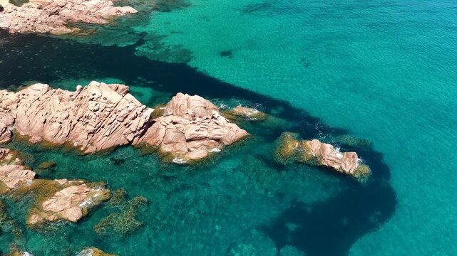 Aerial view of Su Sirboni Beach, Marina di Gairo, Sardinia, Italy. Turquoise sea, rugged red cliffs and hidden coves along the wild Ogliastra coastline