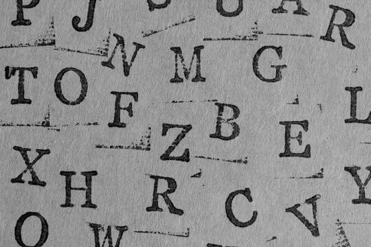 Desaturated, cool toned background various stamped letters on textured paper. Vintage style.