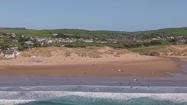 Aerial drone footage of Croyde Beach in North Devon, England, showcasing a sandy shoreline, rolling waves, and a popular surfing destination along the Atlantic coast