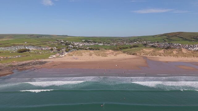 Aerial drone footage of Croyde Beach in North Devon, England, showcasing a sandy shoreline, rolling waves, and a popular surfing destination along the Atlantic coast