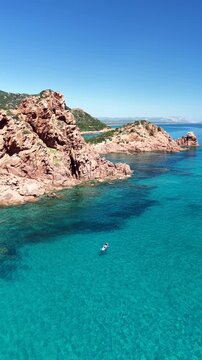 Aerial view of Su Sirboni Beach, Marina di Gairo, Sardinia, Italy. Turquoise sea, rugged red cliffs and hidden coves along the wild Ogliastra coastline