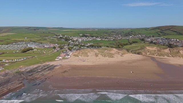 Aerial drone footage of Croyde Beach in North Devon, England, showcasing a sandy shoreline, rolling waves, and a popular surfing destination along the Atlantic coast