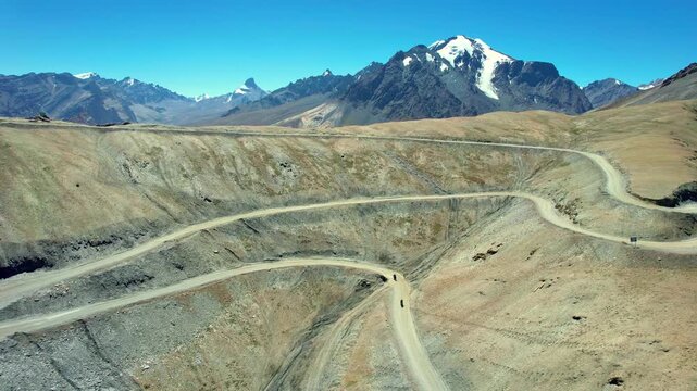 Motorcycles conquer serpentines on the high hills of the Himalayas, surrounded by snow and glaciers