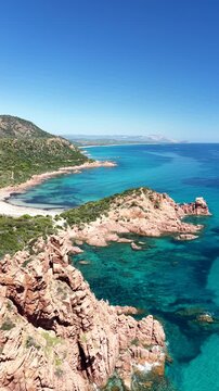 Aerial view of Su Sirboni Beach, Marina di Gairo, Sardinia, Italy. Turquoise sea, rugged red cliffs and hidden coves along the wild Ogliastra coastline