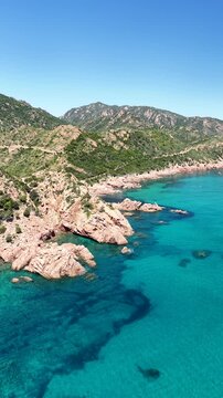 Aerial view of Su Sirboni Beach, Marina di Gairo, Sardinia, Italy. Turquoise sea, rugged red cliffs and hidden coves along the wild Ogliastra coastline
