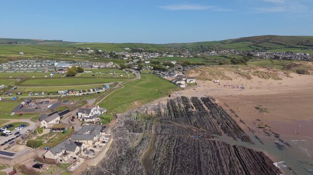 Aerial drone footage of Croyde Beach in North Devon, England, showcasing a sandy shoreline, rolling waves, and a popular surfing destination along the Atlantic coast