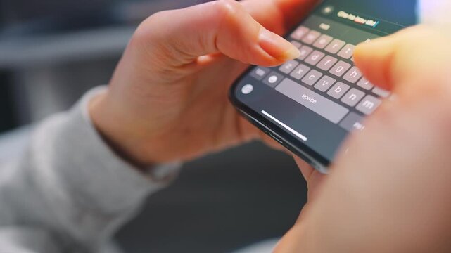 Female hands typing text on smartphone close-up.