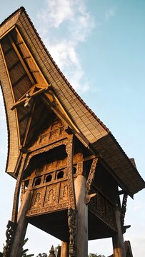 Low Angle View of Traditional Rumah Adat House Architecture with Intricate Wood Carvings and Soaring Roofline