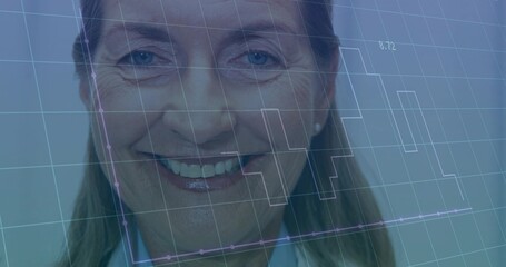 Smiling senior woman facing camera in clinic, wearing lab coat, stud earrings, showing data overlay